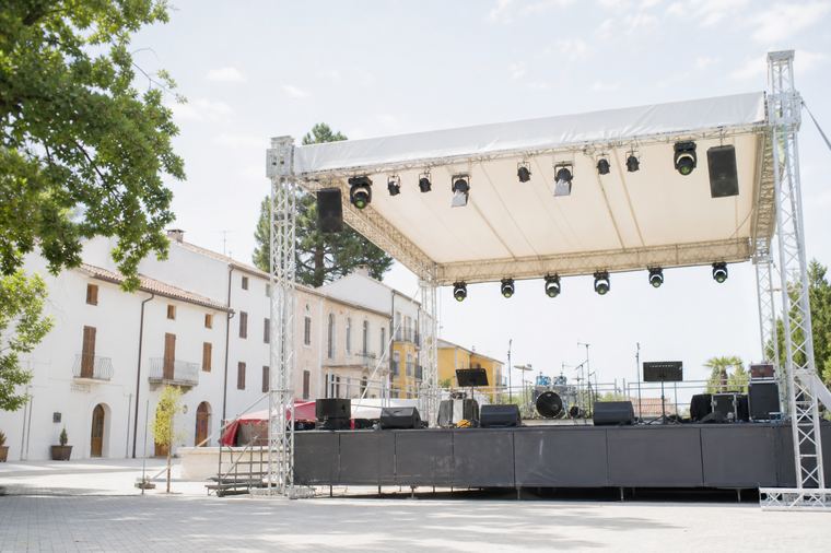 Un uomo con giacca scura resta solo sul palco vuoto prima dello spettacolo.