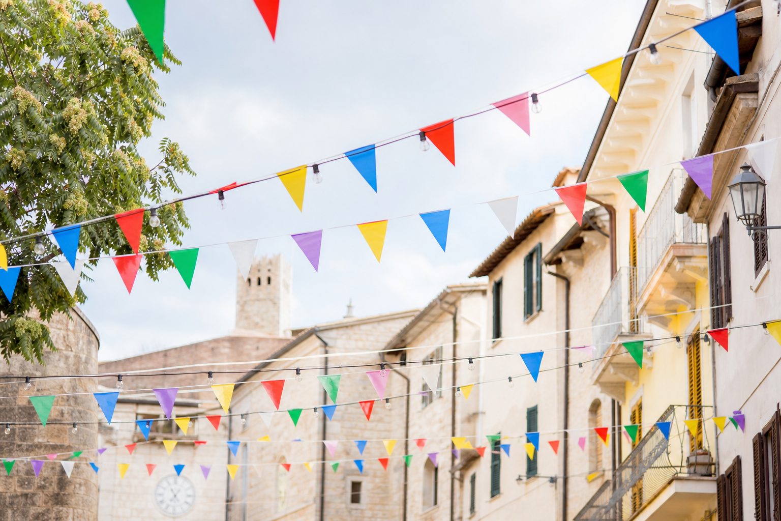 Luci decorative accese si riflettono su una pozzanghera lungo la strada della festa.
