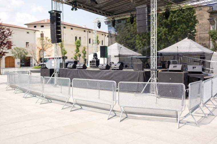 Persone in piedi sul palco allestito, riprese in controluce durante un evento serale.