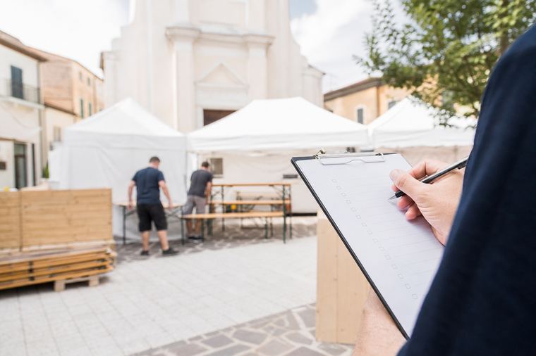 Un gruppo di volontari prepara insieme il fuoco all'aperto durante l'allestimento della festa.